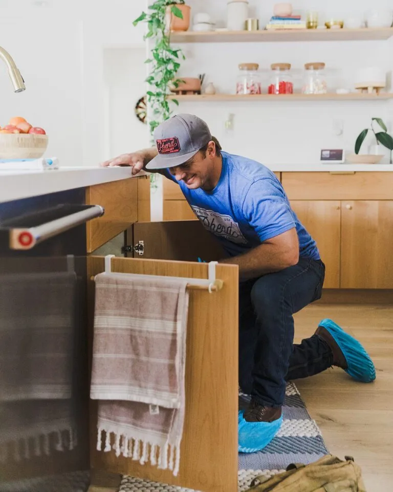Phend Plumbing technician connecting new supply lines under a sink after a whole-home repipe