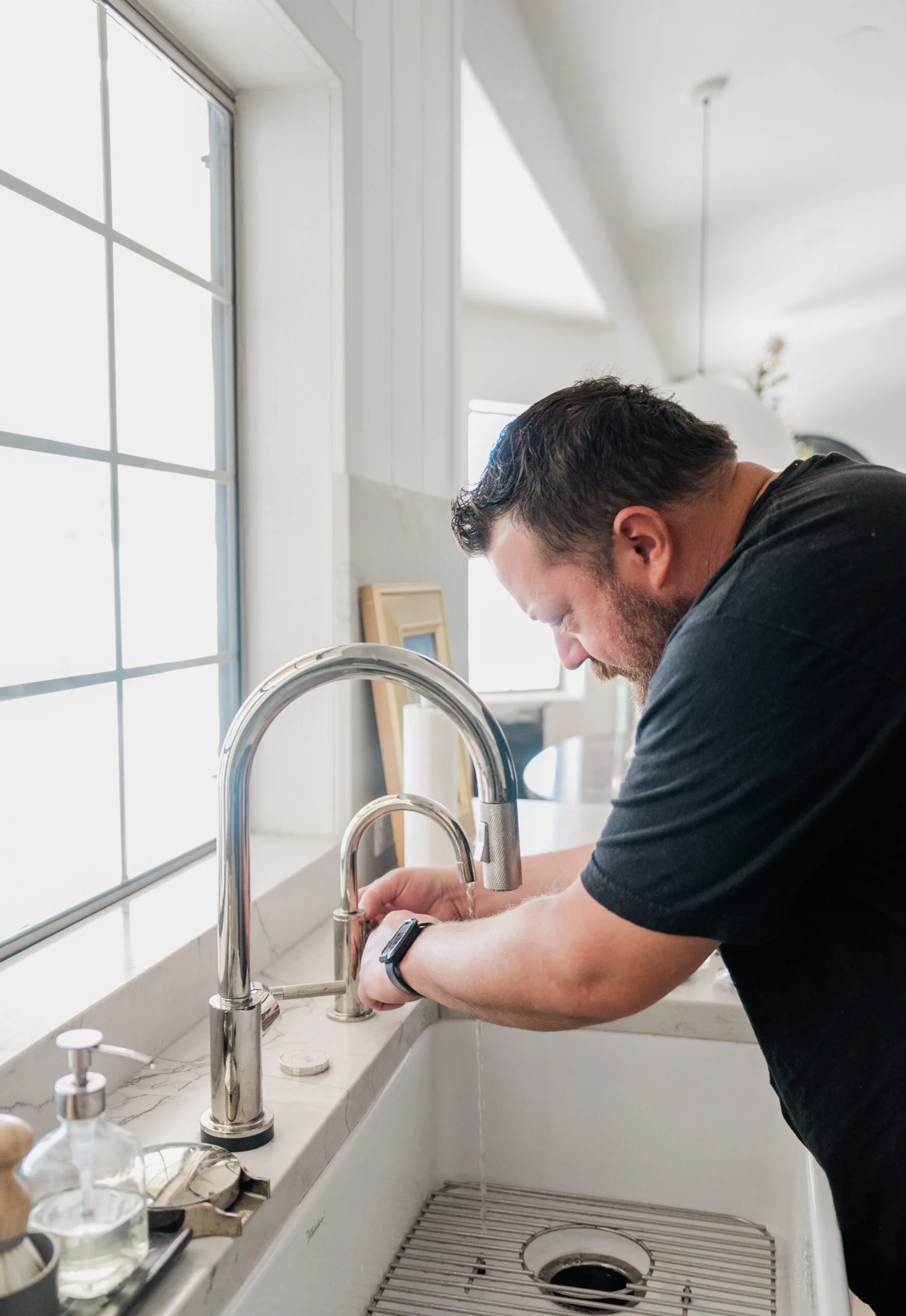 Phend Plumbing technician at a chrome kitchen faucet on a marble counter