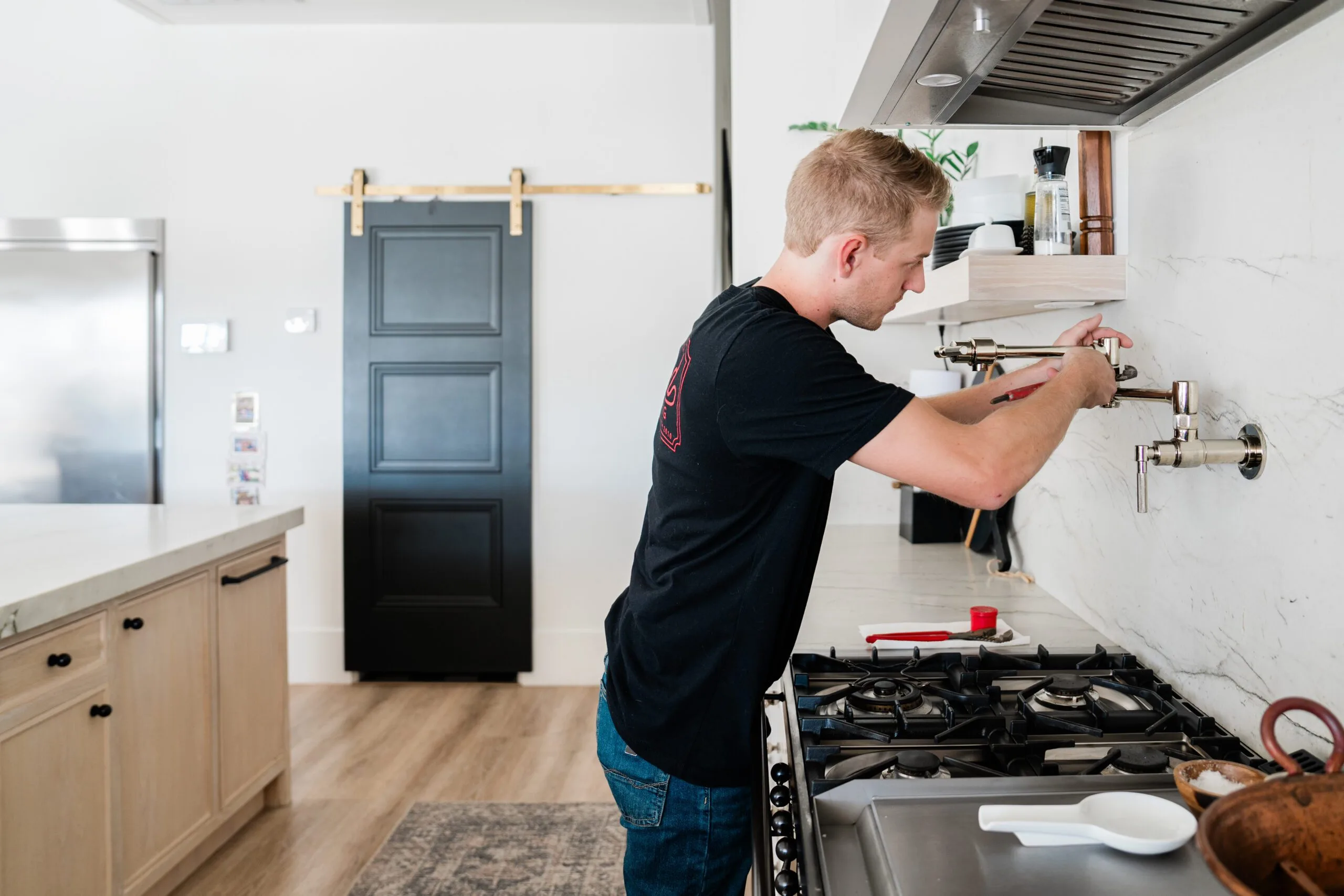 Phend Plumbing technician installing a pot filler near a gas range