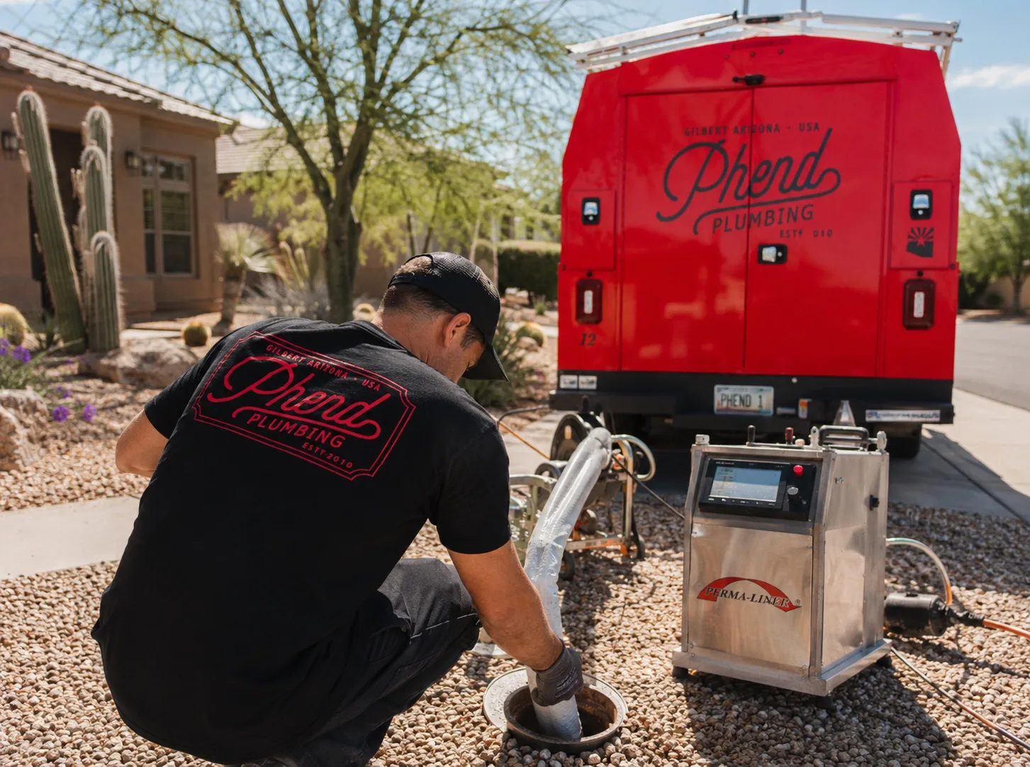 Phend Plumbing technician operating a hydro-jet unit at a residential sewer cleanout