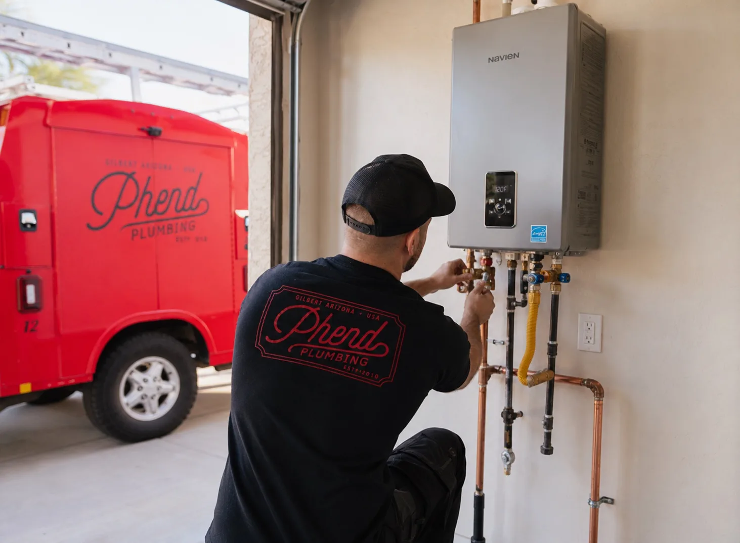 Phend Plumbing technician installing a tankless water heater in an East Valley garage